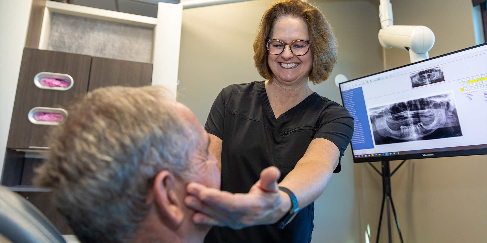 Staff member assisting patient within the dental center for treatment