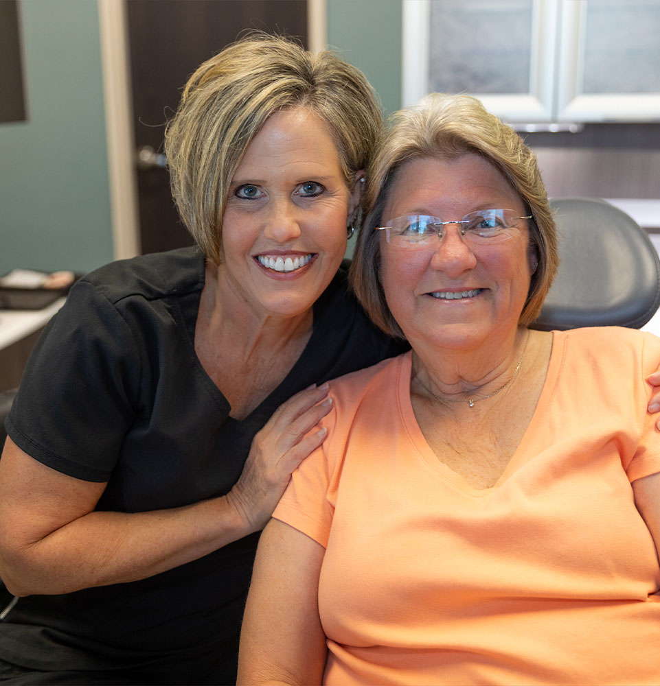 patient and staff member smiling after patient treatment inside of the dental center