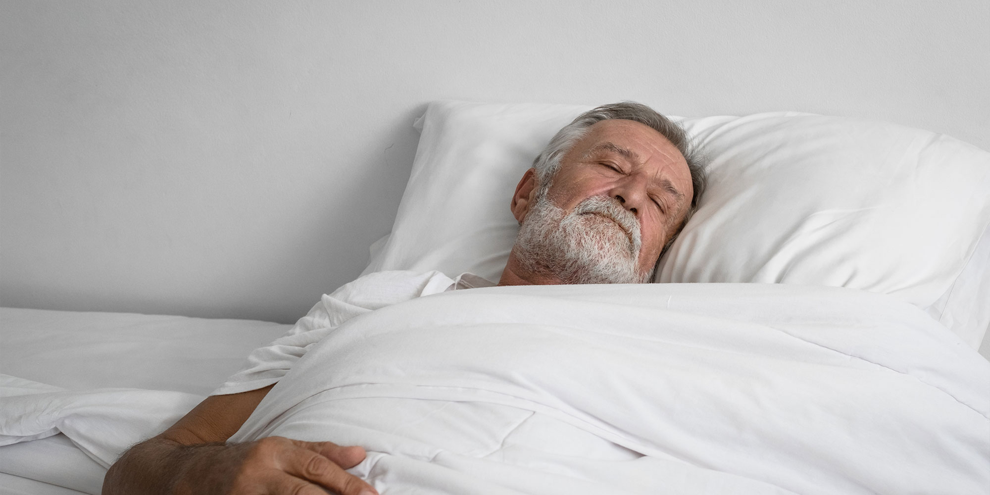 older male sleeping peacefully in their bed